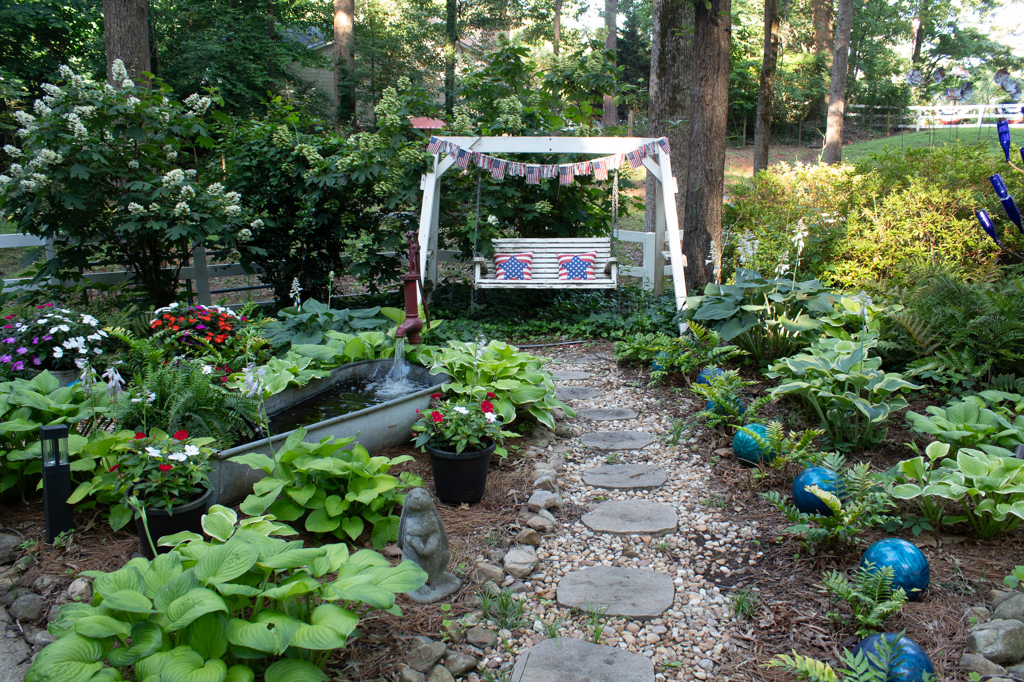 Garden path leading to a white swing