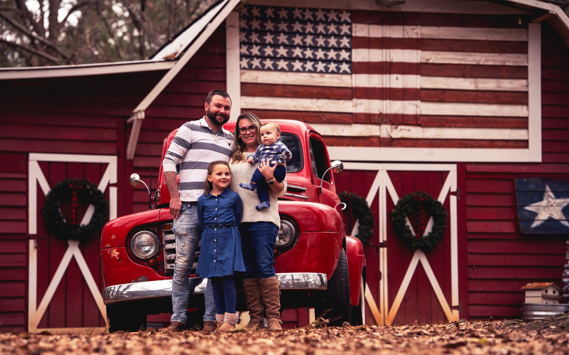 Family at the barn with the red truck