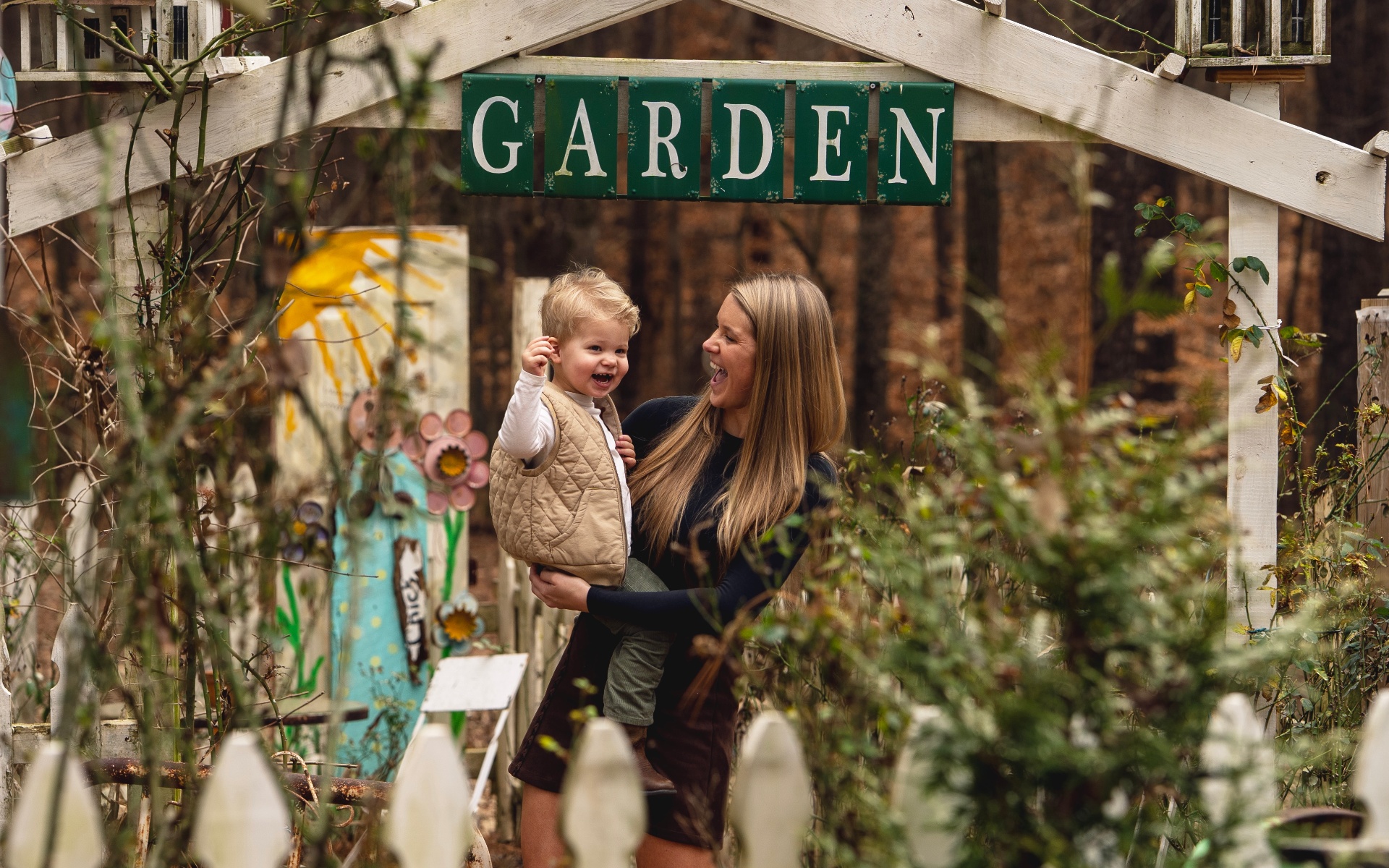 Mom and son laughing at the garden sign