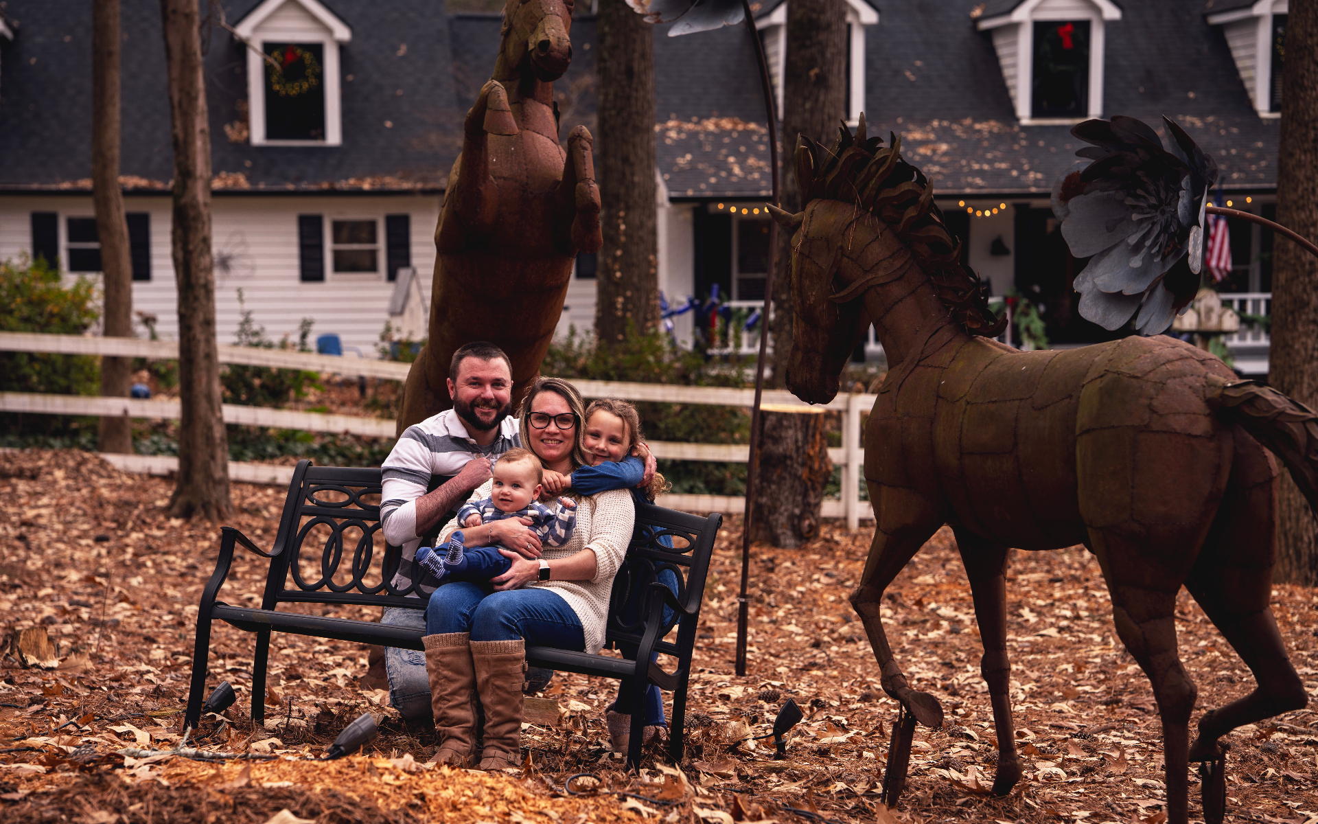 Family on a bench with horse sculptures
