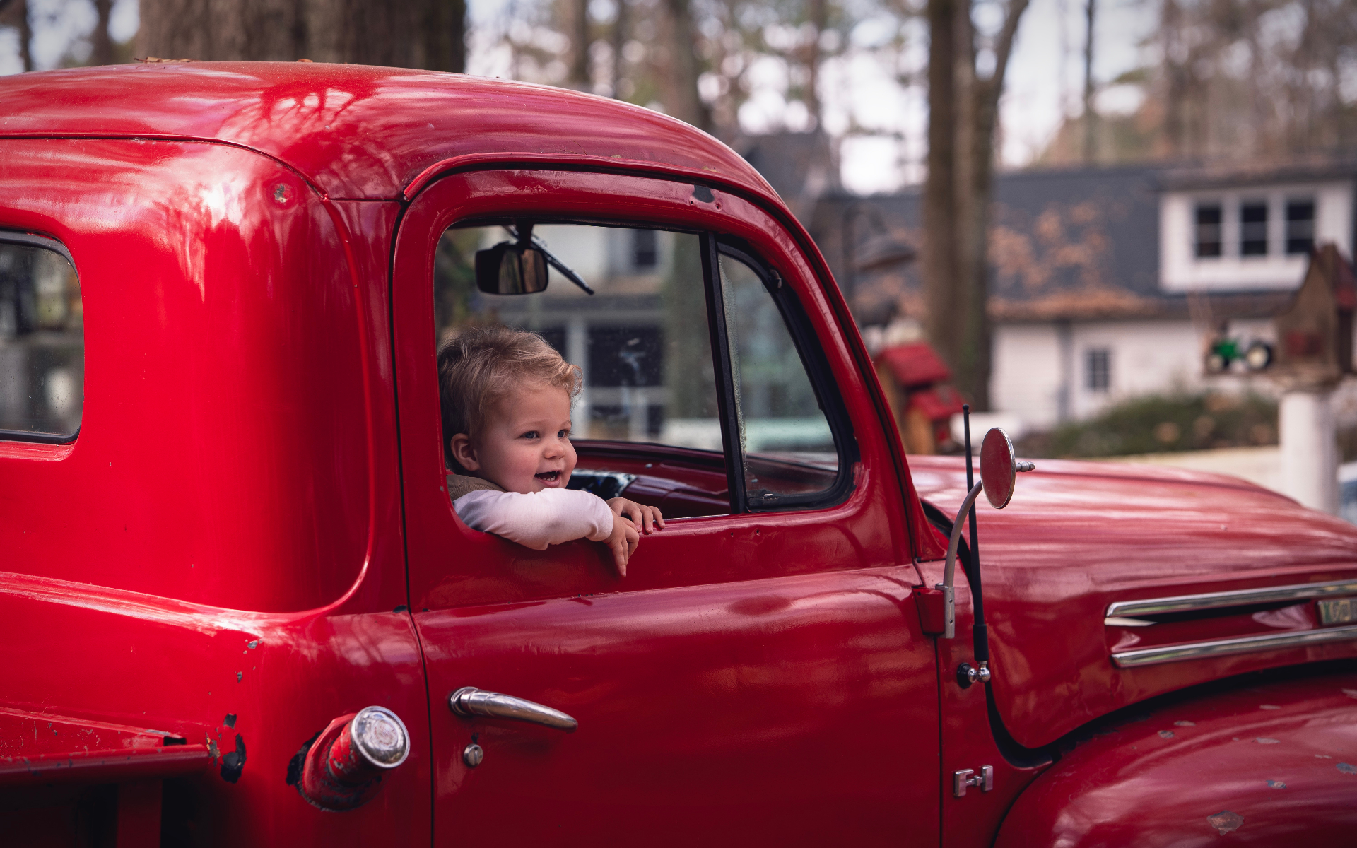 Little boy peeking out of the red truck